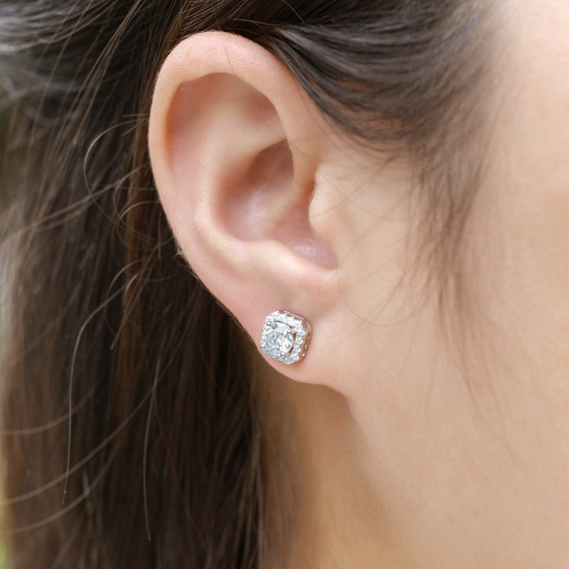 Model wearing round diamond cushion-shaped halo stud earrings.