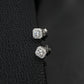 Round diamond cushion halo stud earrings displayed on black textured leather background.