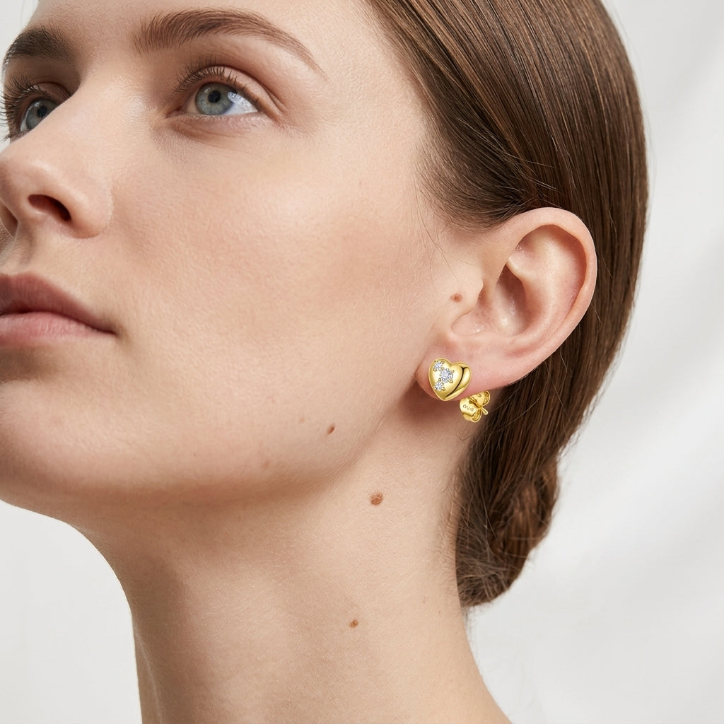 Lifestyle fashion lookbook portrait of a model styling 18k gold puffy heart moissanite stud earrings near her neck.