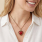 A model wearing the Disney x Kendra Scott Snow White royal red heart locket pendant necklace to show the length and style