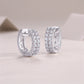 Angled view of double row pave moissanite hinged sleeper hoop earrings.