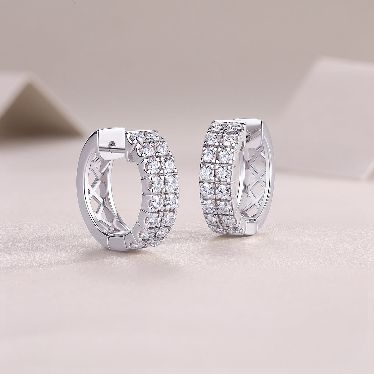Angled view of double row pave moissanite hinged sleeper hoop earrings.