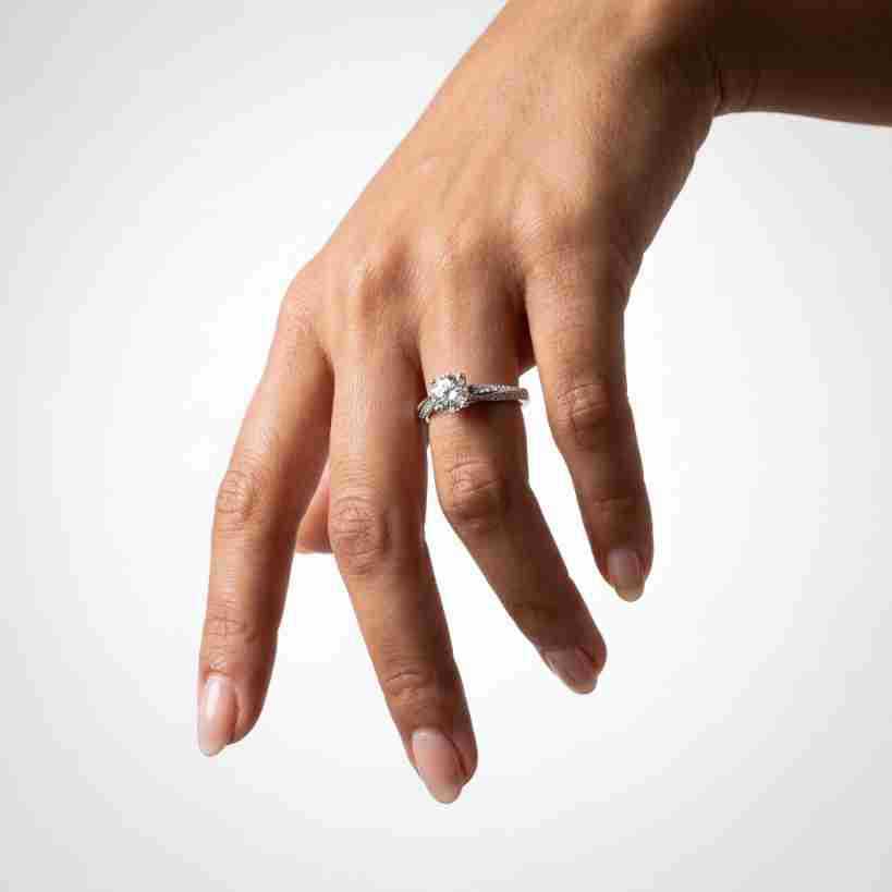 Full hand shot of model displaying double row pavé engagement ring.