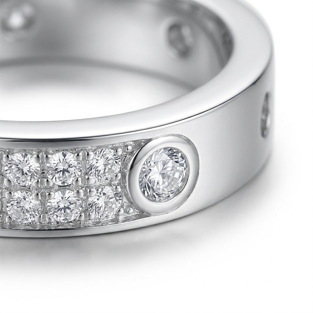 Macro close-up shot of the double row pavé moissanite stones and bezel setting on a silver eternity band.