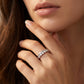Closeup lookbook shot of a model's hand near her chin, displaying an effortless luxury d vvs1 moissanite enhancer band.