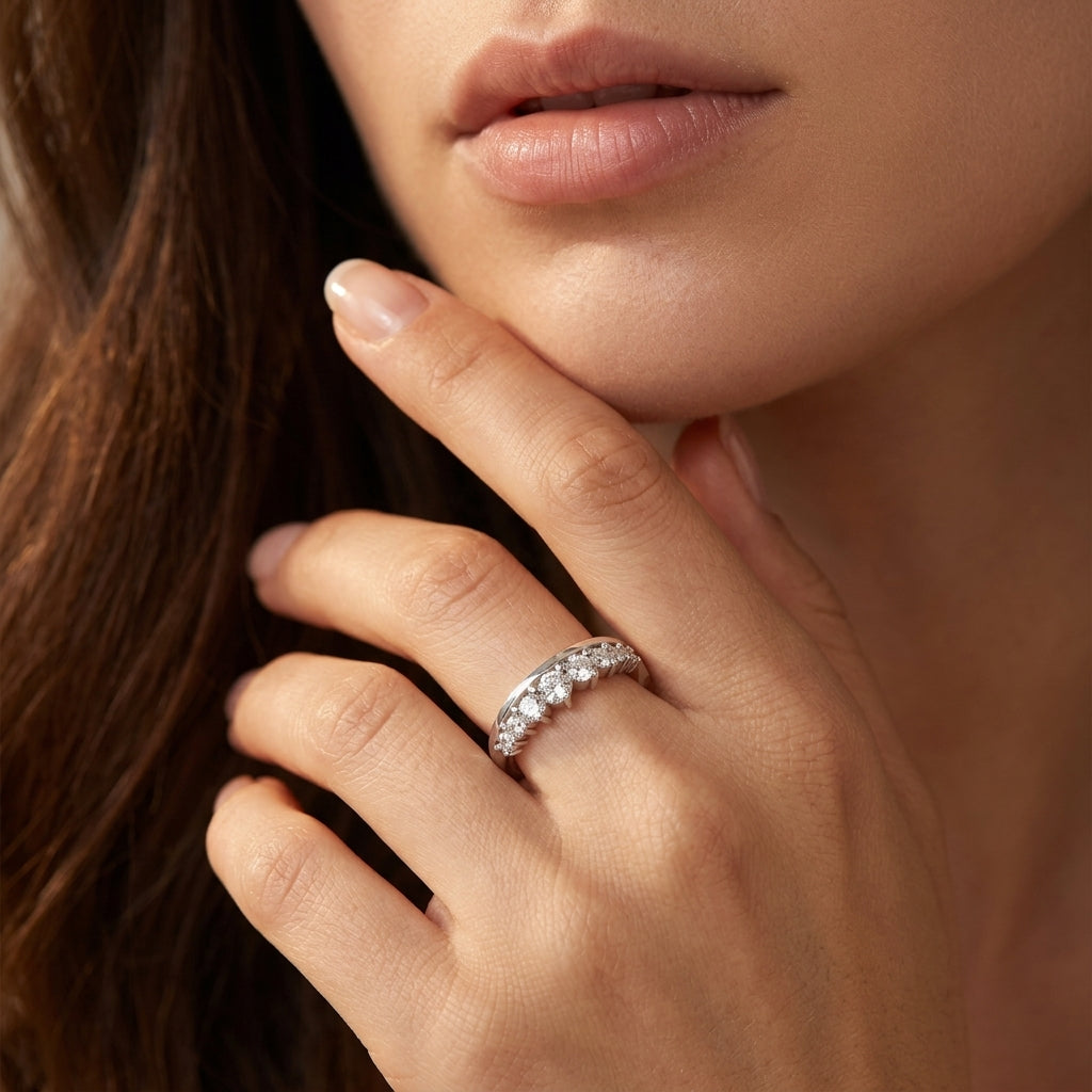 Closeup lookbook shot of a model's hand near her chin, displaying an effortless luxury d vvs1 moissanite enhancer band.