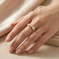 Closeup lookbook shot of a model's hand resting on silk, showcasing the effortless luxury dramatic five stone heart anniversary band.