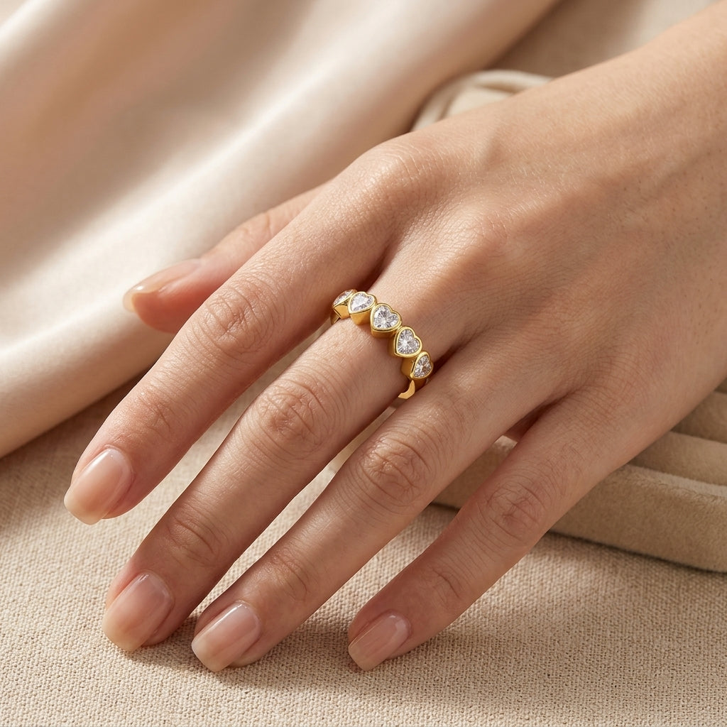 Closeup lookbook shot of a model's hand resting on silk, showcasing the effortless luxury dramatic five stone heart anniversary band.