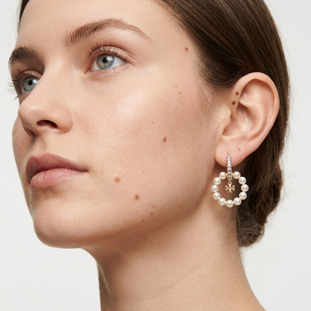 Close up lifestyle view of a model demonstrating the elegant movement of effortless luxury white pearl drop hoops.