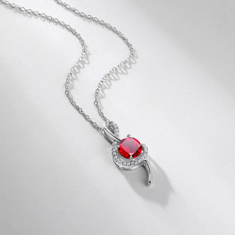 Elegant round-cut ruby treble clef pendant necklace displayed on a soft shaded white surface.