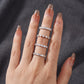 Model showcasing emerald cut diamond half eternity band stacked across multiple fingers.