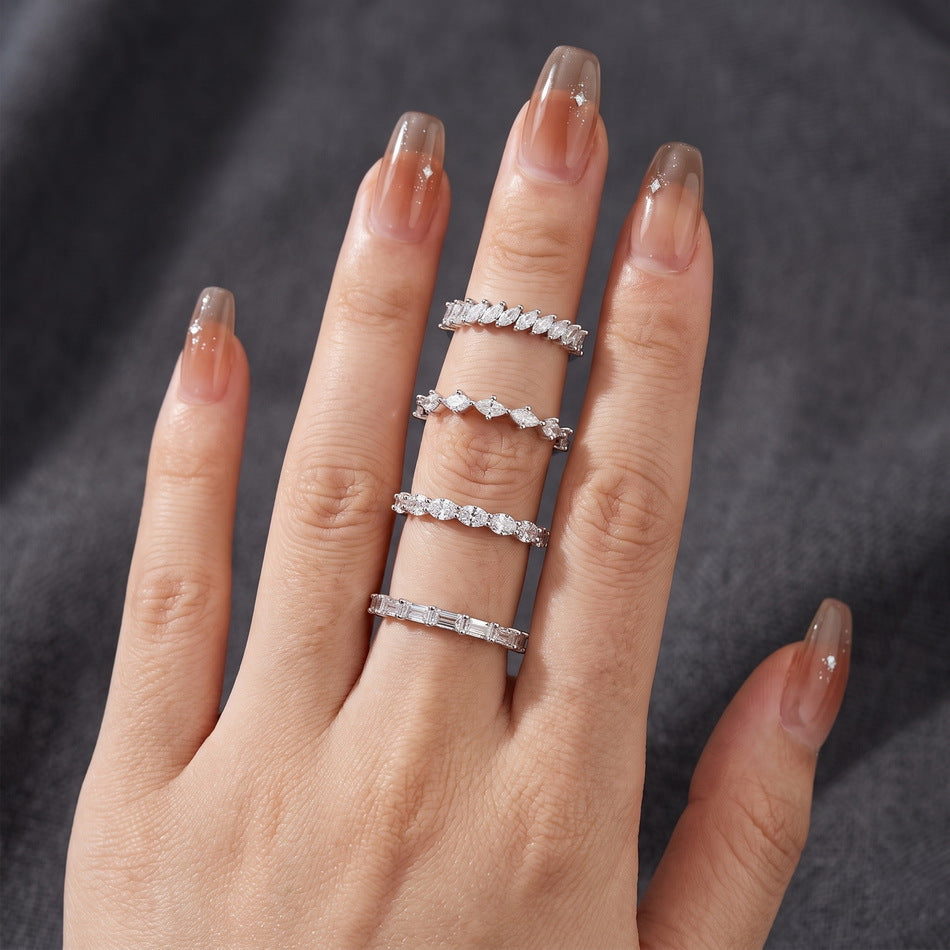 Model showcasing emerald cut diamond half eternity band stacked across multiple fingers.