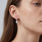Model wearing emerald cut lab grown diamond padlock dangle huggie earring on earlobe