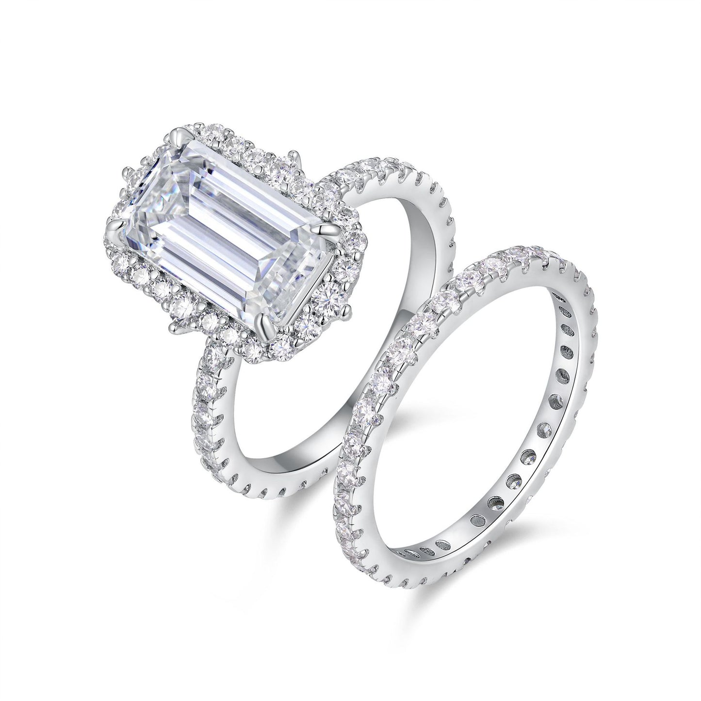 Emerald cut moissanite halo engagement ring with pave stacking wedding band on white background.
