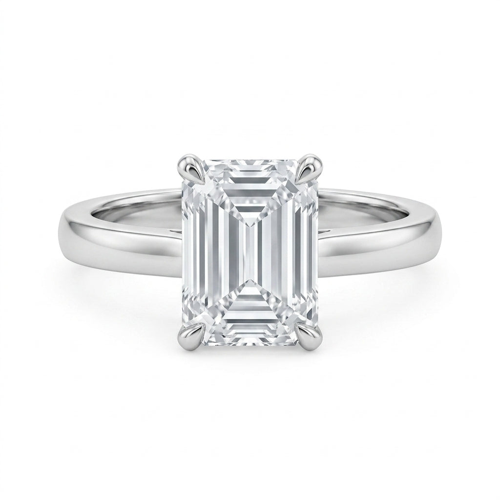 Emerald cut moissanite solitaire engagement ring with high-polish silver plain band on white background.