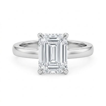 Emerald cut moissanite solitaire engagement ring with high-polish silver plain band on white background.