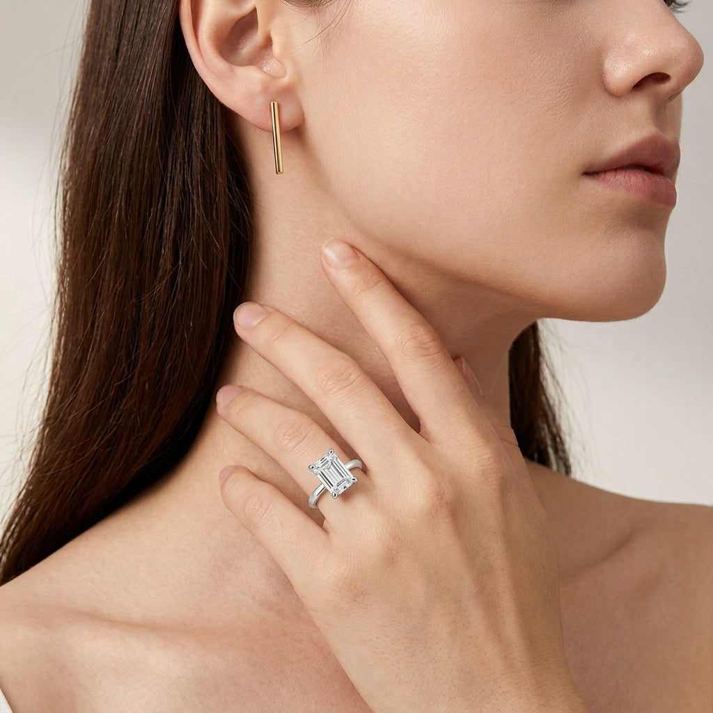Close-up view of a model wearing minimalist emerald cut moissanite solitaire ring.