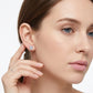 Model wearing 5x7mm emerald cut moissanite solitaire stud earrings.