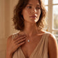 Model posing with emerald cut octagonal halo bezel pendant necklace wearing elegant dress.