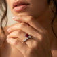 Close-up lifestyle view of a model wearing an emerald-cut ruby and princess-cut diamond Toi et Moi ring on her finger.
