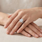 Model showing emerald cut moissanite halo pave stacking bridal set on hand.