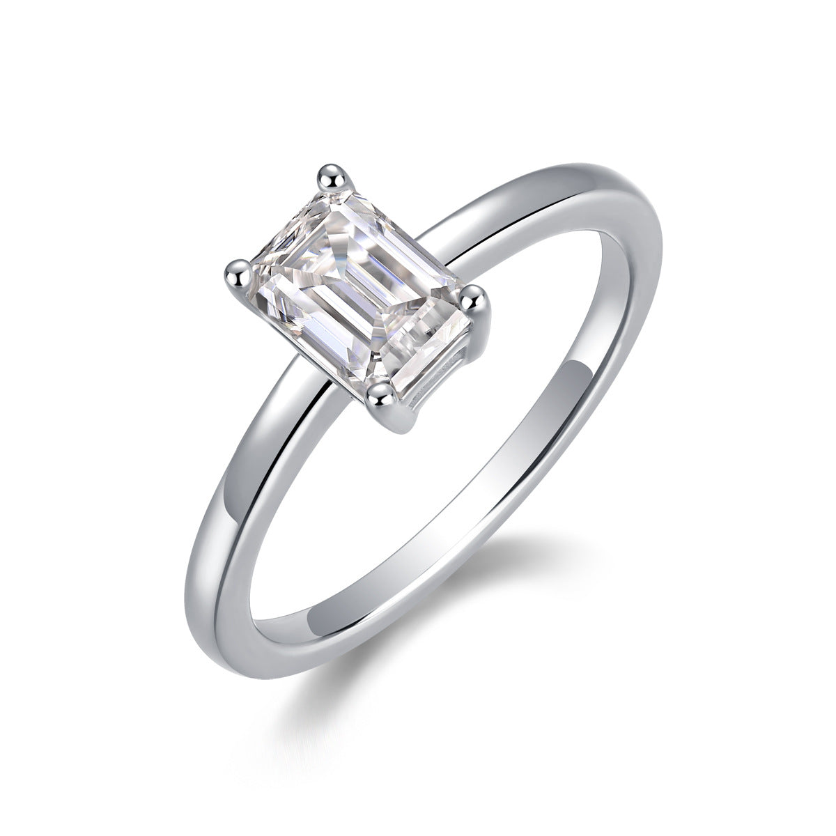 Silver emerald cut moissanite solitaire ring with plain shank standing on display.