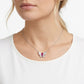 Far shot view of a model showcasing an ethereal ruby butterfly statement pendant necklace on her collarbone.