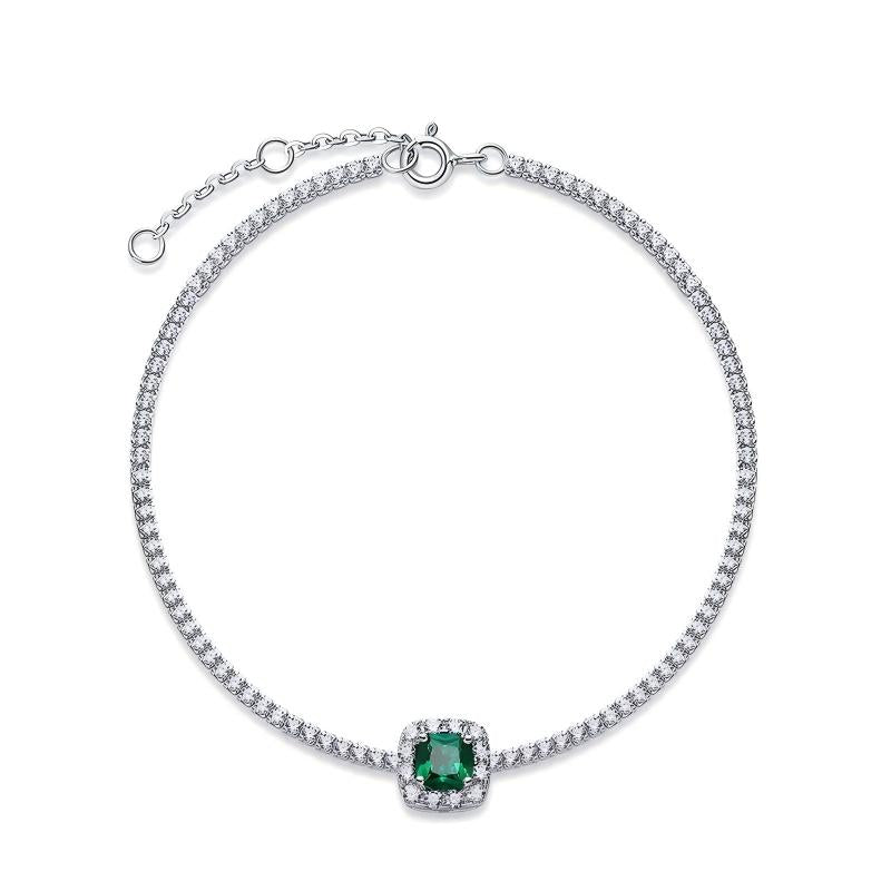 Overhead circular display view of a fine jewelry cushion-cut emerald halo tennis bracelet on a white backdrop.