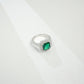 Macro close-up product view of a fine jewelry emerald double halo ring with a diamond encrusted split-shank pave band.