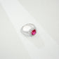 Macro close-up product view of a fine jewelry ruby double halo ring with a diamond encrusted split-shank pave band.