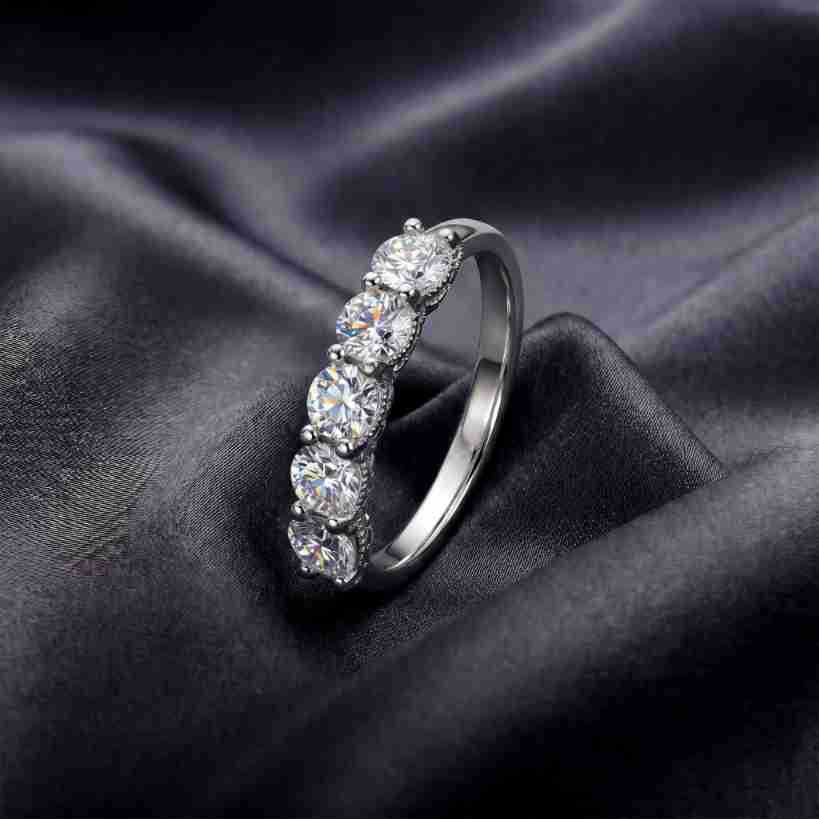 Angled perspective shot of five-stone round brilliant lab grown diamond ring on dark silk.