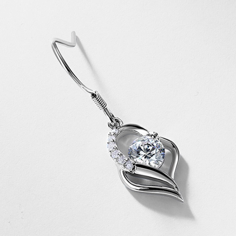 Angled flat lay view of single round diamond floating open heart dangle earring with fishhook.