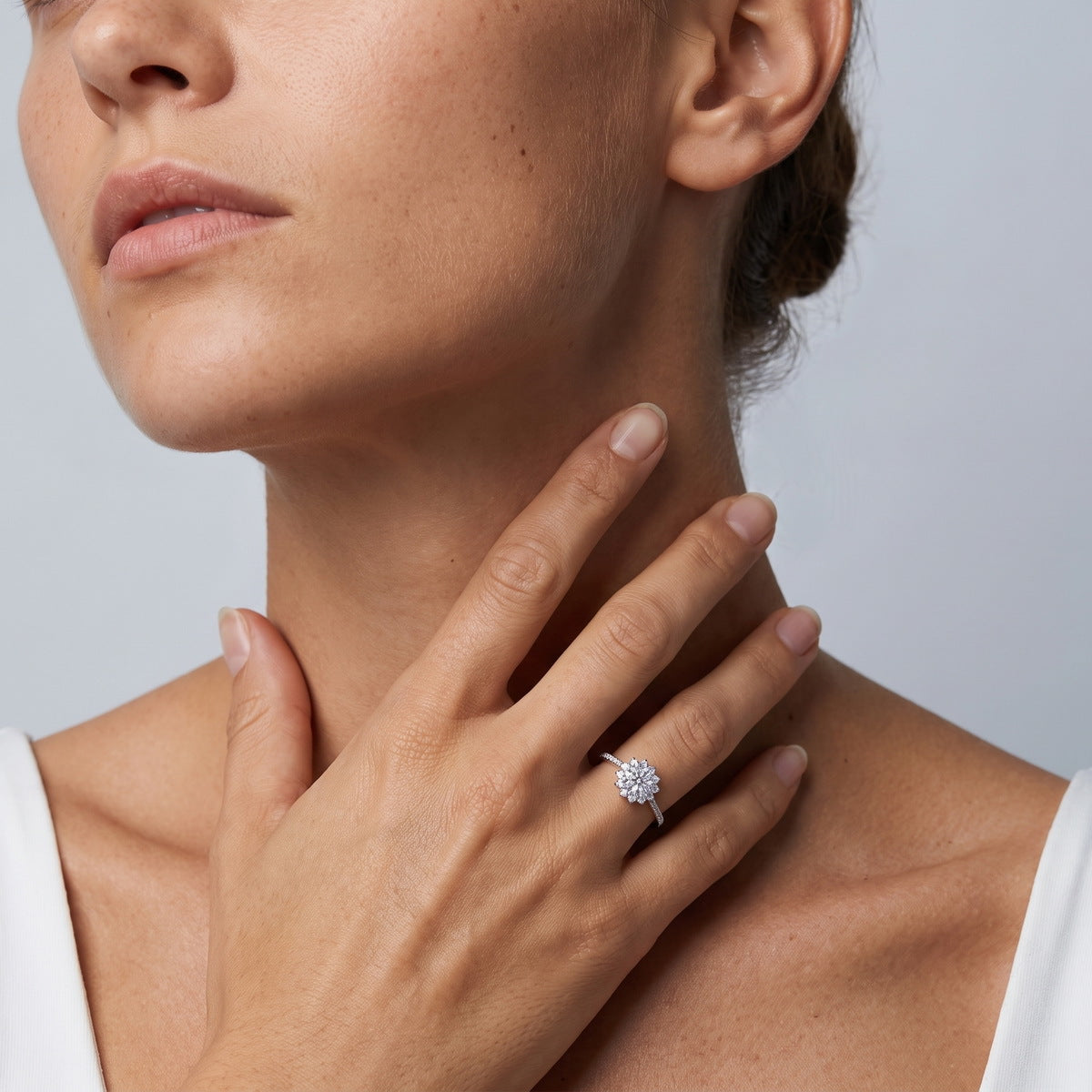 Model wearing floral sunburst halo lab grown diamond engagement ring on finger