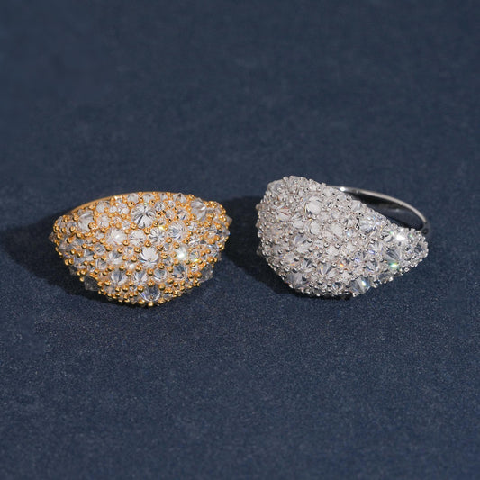 Full pave dome moissanite signet statement rings in silver and gold options on dark blue surface