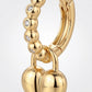 Macro close-up showing beaded moissanite hoop texture and hinged snap closure with gold heart lock dangle.