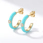 Pair of gold turquoise enamel half hoop stud earrings with butterfly post backs.