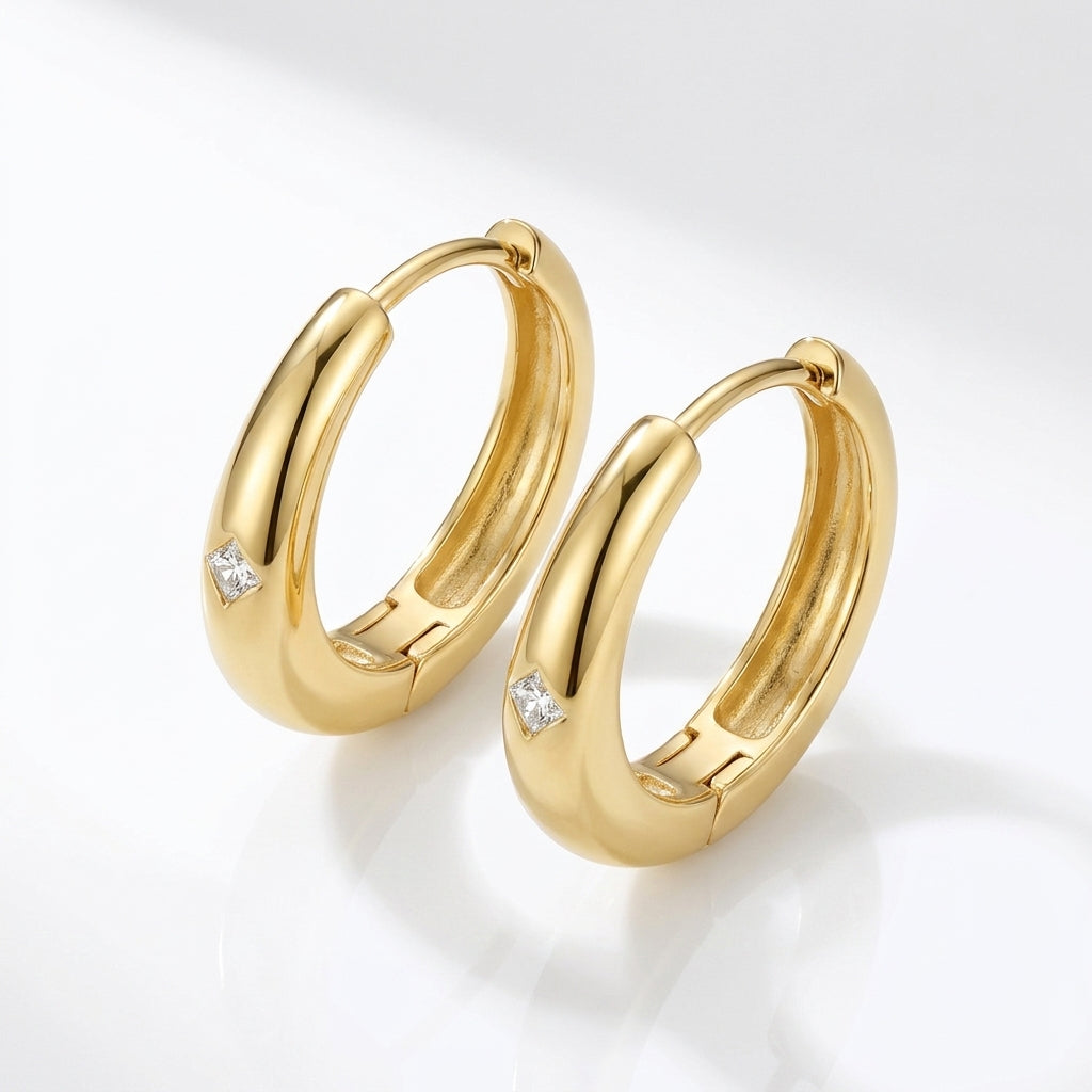 Pair of classic gold thick dome huggie hoop earrings featuring flush set moissanites.