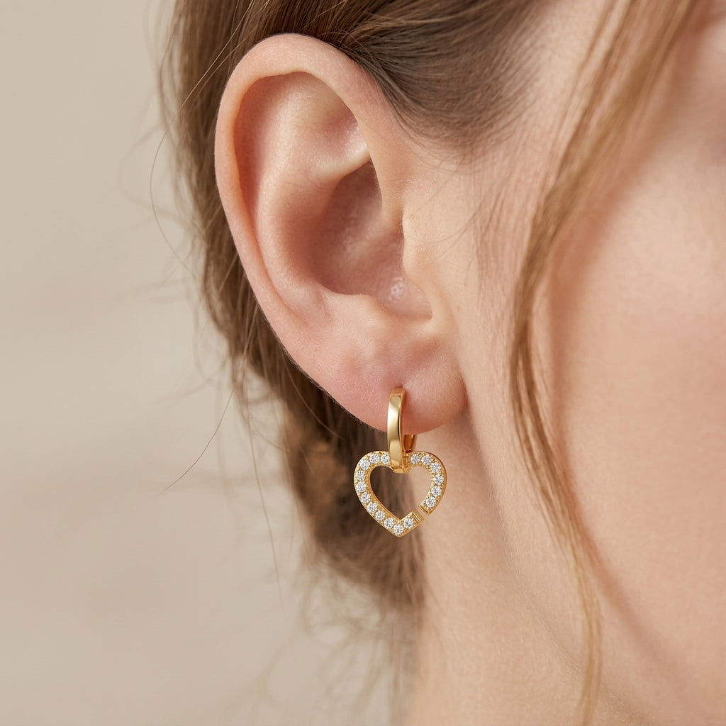 Close-up of a model wearing gold double heart moissanite huggie dangle earrings.