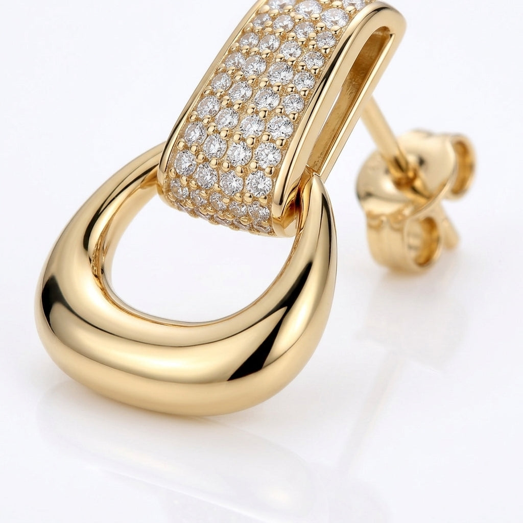 Macro close-up of gold equestrian stirrup door knocker dangle earrings with brilliant pavé moissanite.