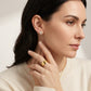 Close-up view of a model wearing gold marquise cut moissanite four-leaf clover stud earrings.
