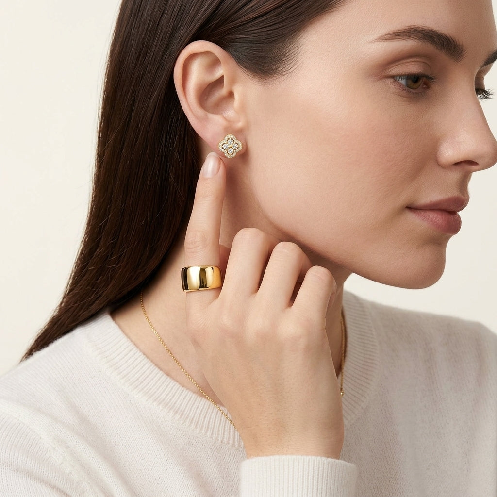 Close-up view of a model wearing gold round cut moissanite clover cluster halo stud earrings.