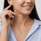 Model smiling and wearing the gold MOM heart cut moissanite necklace in a lifestyle photo.