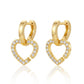 Pair of gold heart shaped huggie hoops with dangling pavé moissanite heart charms.