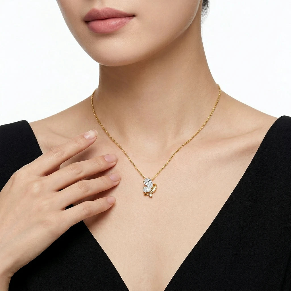 Model wearing gold pear cut moissanite butterfly charm necklace.