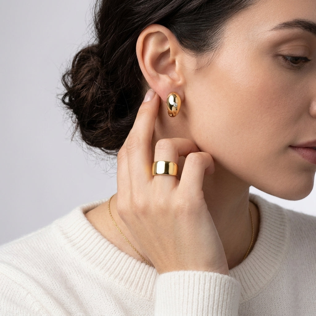 Model wearing gold chunky teardrop moissanite earrings paired with a matching gold ring.