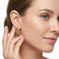Model wearing classic gold thick moissanite huggie hoop earrings in a natural lifestyle photo.