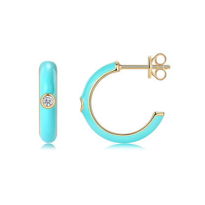Gold and turquoise blue enamel open hoop stud earrings with bezel set moissanite on white background.
