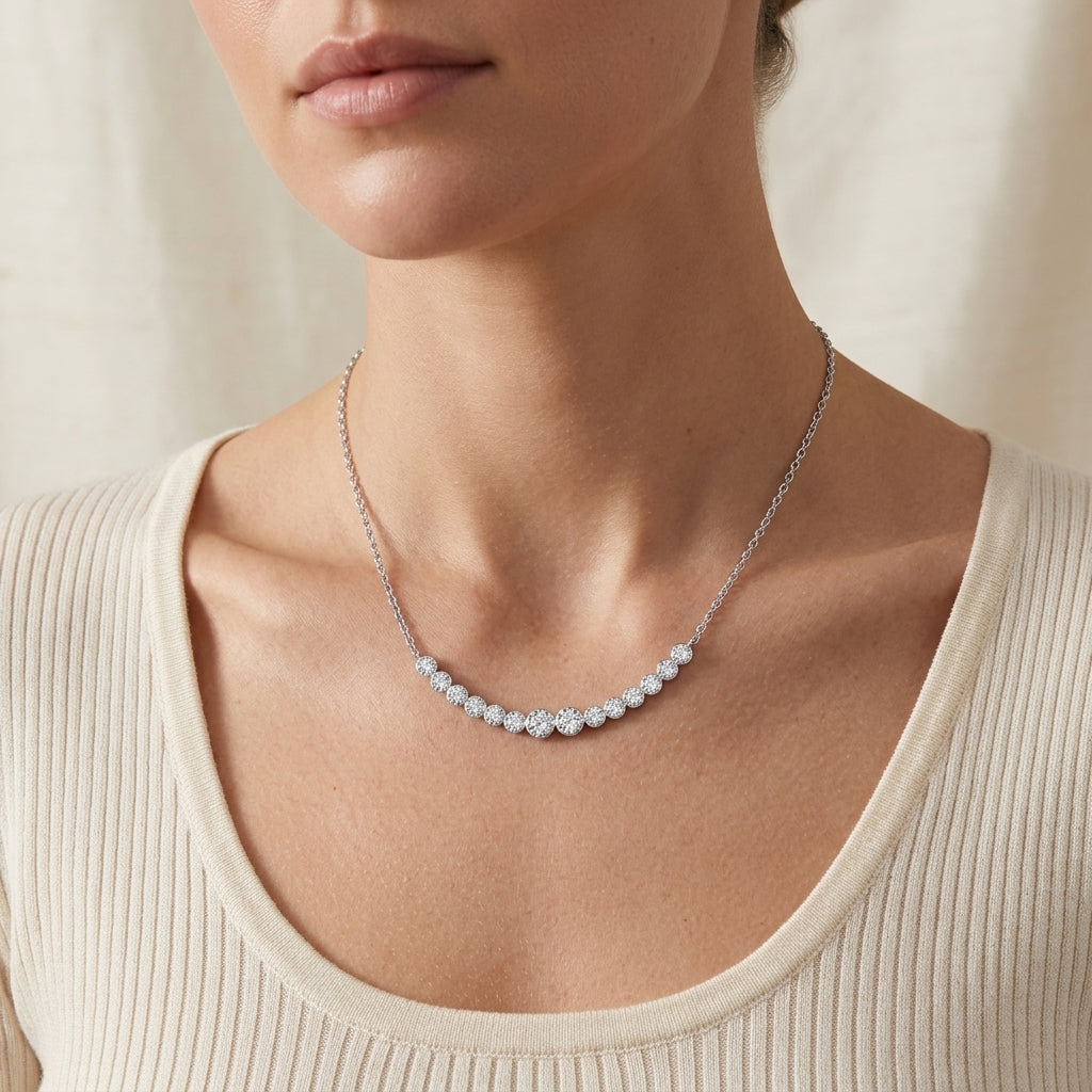 Model wearing graduated bezel set moissanite curved smile necklace on collarbone.