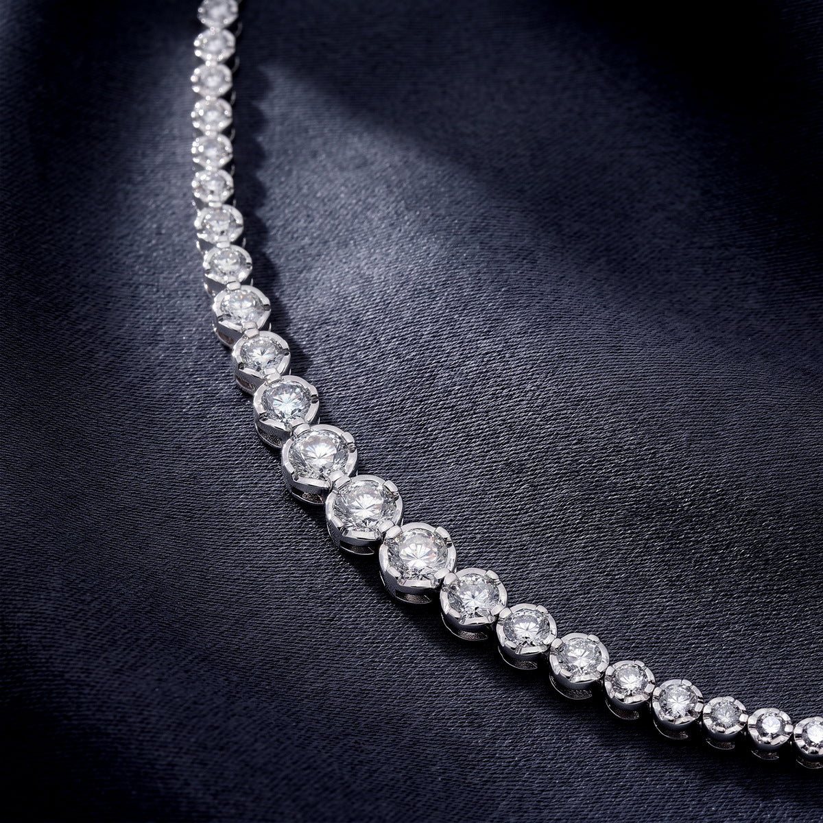 Curved link profile of graduated bezel round lab-grown diamond tennis bracelet.