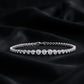 Full circle view of graduated bezel round lab-grown diamond tennis bracelet on dark silk.